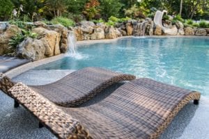 Woven lounge chairs with a curvy base by the poolside.