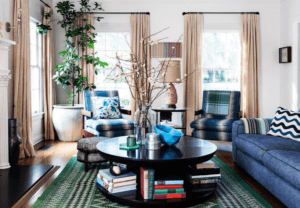 Living room with denim couch and green rug.