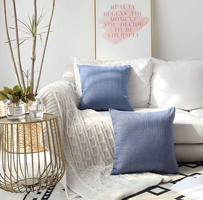 Blue denim pillows on a white couch.