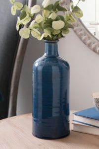 Blue vase with green flowers.