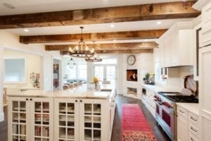 Luxurious white kitchen with wooden beams across the ceiling.
