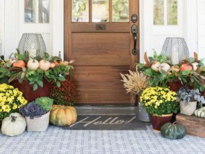 Outdoor entrance of a home with fall decor outside.
