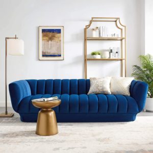blue couch with gold furniture accents around it