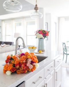 White kitchen with colorful flowers on the counter